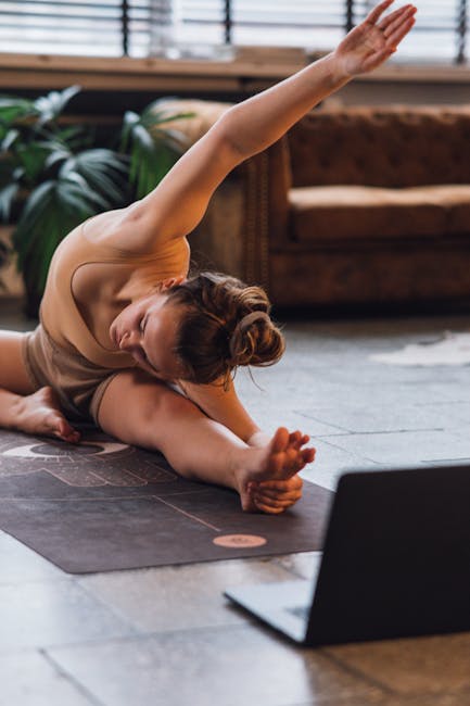 Woman in a peaceful savasana pose on a yoga mat in a warmly lit room.